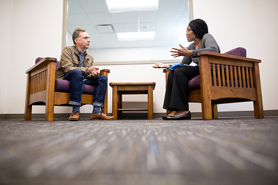 Photo of a Chatham University counseling psychology student counseling a man sitting across from her. 