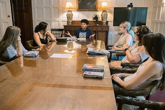 Photo of a male Chatham University student seated next to classmates, paying attention to an unseen lecturer