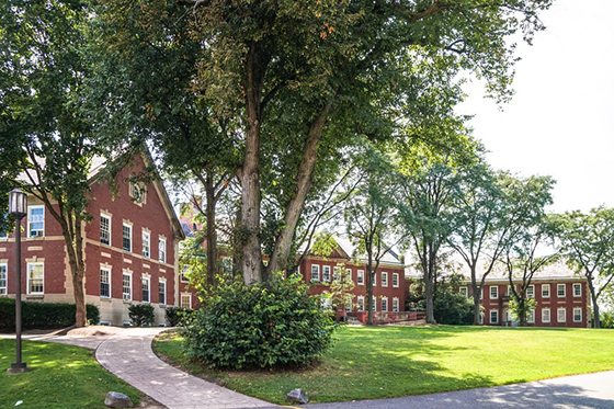 Redbrick academic buildings frame a green quad on Chatham University's Shadyside campus. 