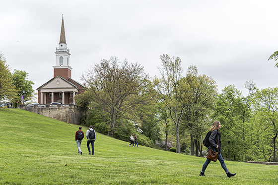 Photo of Chatham University students walking across the grassy Shadyside Campus