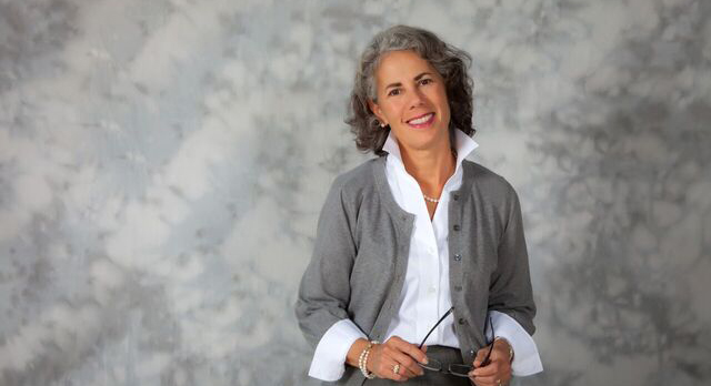 Photo of a Chatham University faculty member posing in front of a grey background