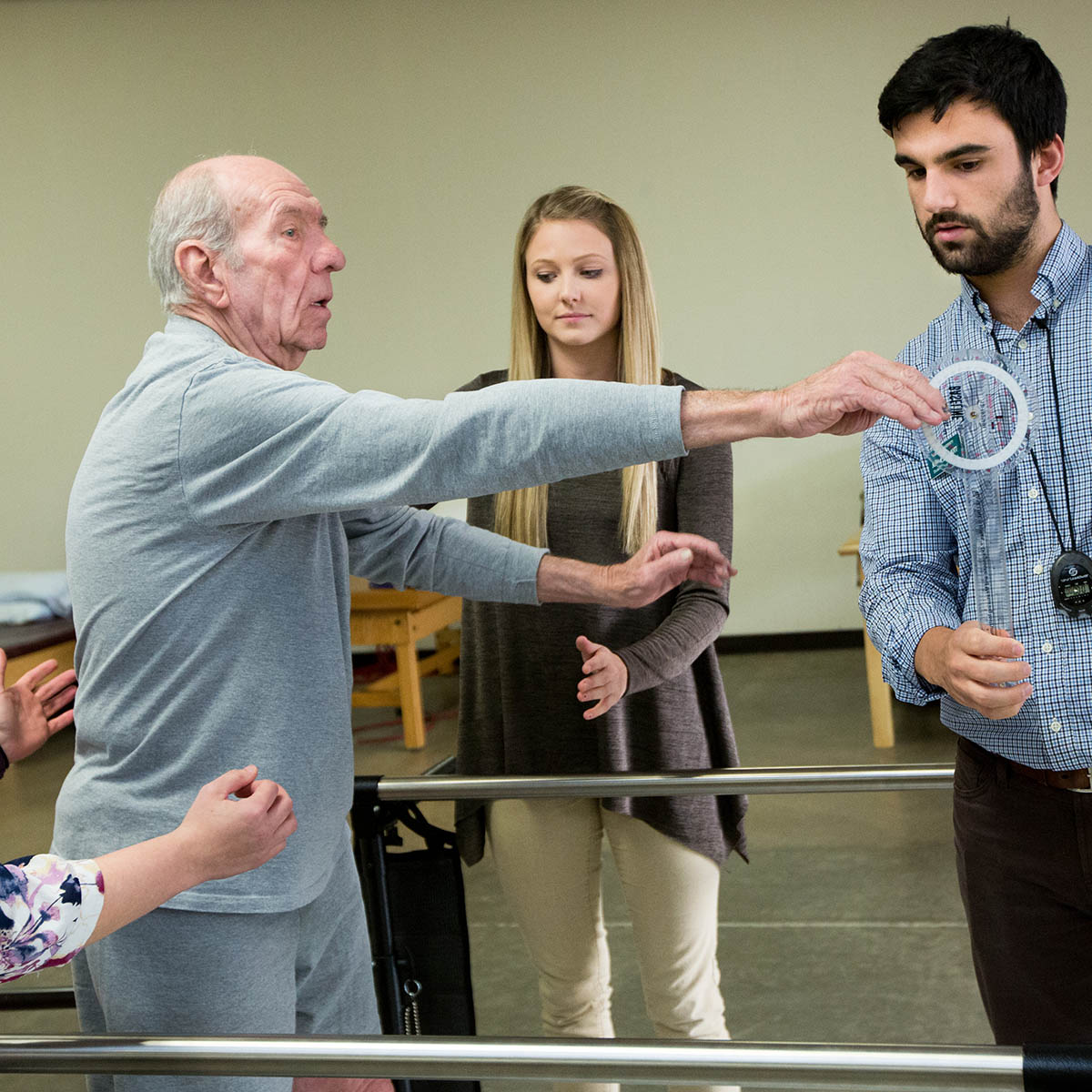 Two physical therapy doctorate students working with an elderly man