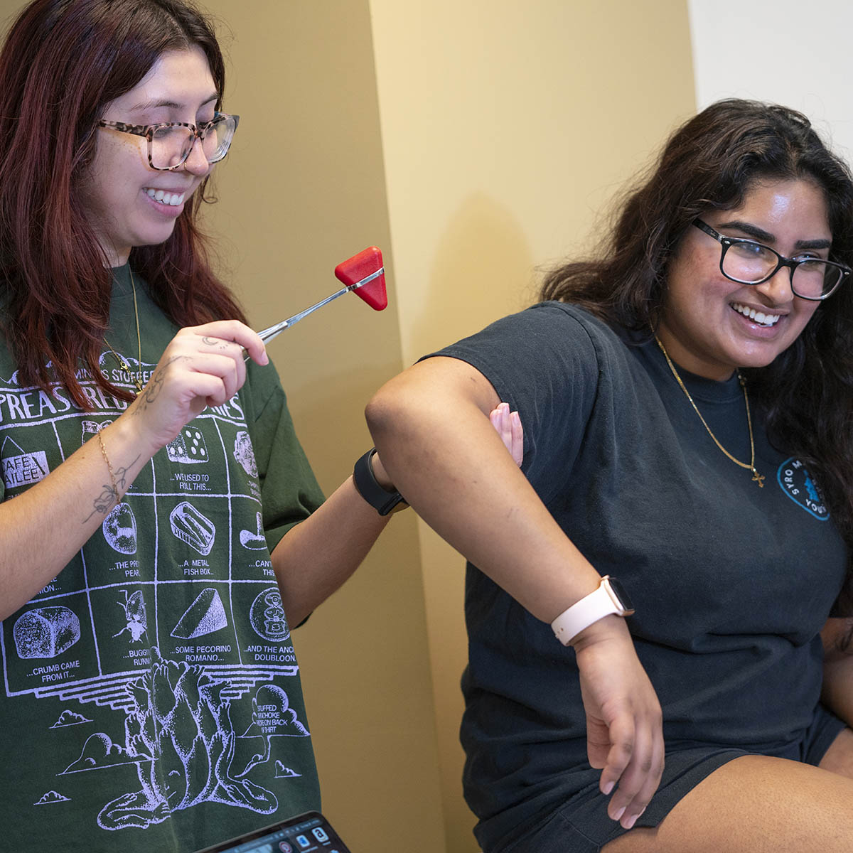 Two physician assistant graduate students testing reflexes together