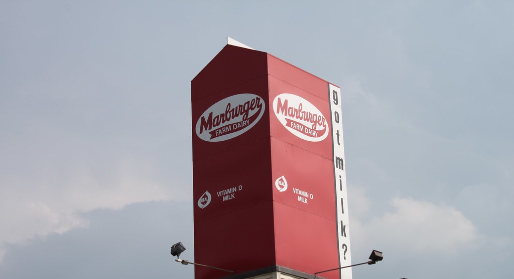 Photo of a large red milk carton reading "Marburger Dairy" on top of a production facility in Pennsylvania. 