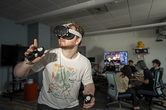 Photo of a student in a virtual reality machine in the immersive media lab