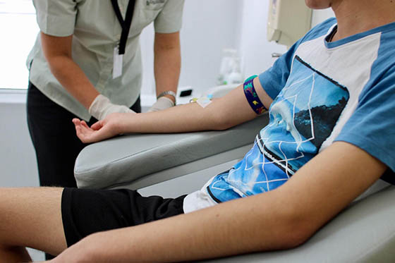 Close-up photo of a nurse preparing to draw blood from a seated patient