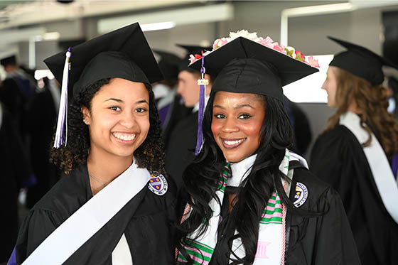 Three Chatham University graduates in gowns and caps pose for a photo