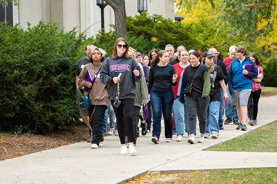 Photo of two Chatham University students walking across the Shadyside Campus, talking and walking down stairs