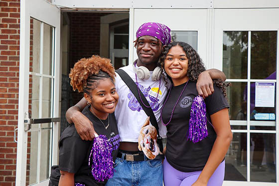 Photo of two Chatham University students walking on Shadyside Campus, with two other students seated nearby on a bench