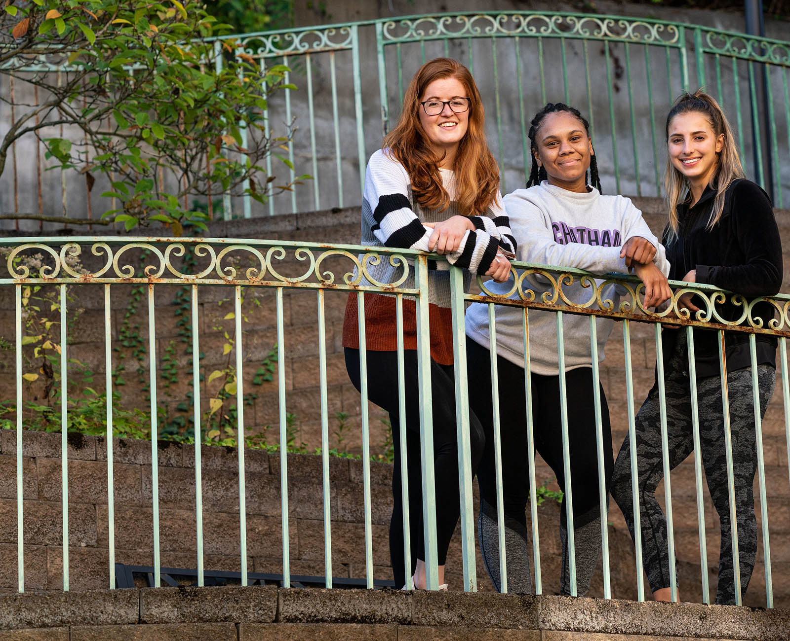 Photo of third-year entry-level Doctor of Occupational Therapy students Emily Smith, Dominique Peterson, and Kayla Raybuck posing against a fence at Vincentian Schenley Gardens