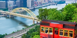 Photo of Pittsburgh's red incline car framing the city's skyline in the distance. 
