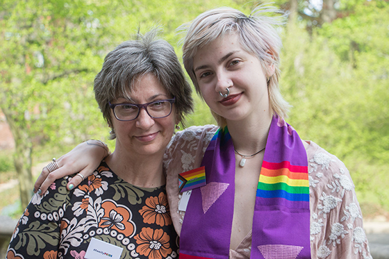 Photo of a Chatham University student with a rainbow graduation stole at Lavender Graduation, accompanied by an older woman