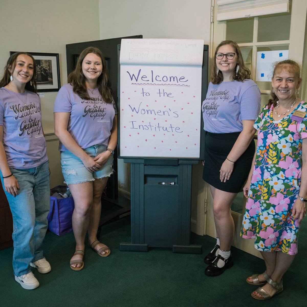 Jessie Ramey, right, poses for a photo with students at the Women’s Institute