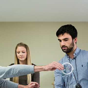 Two physical therapy doctorate students working with an elderly man