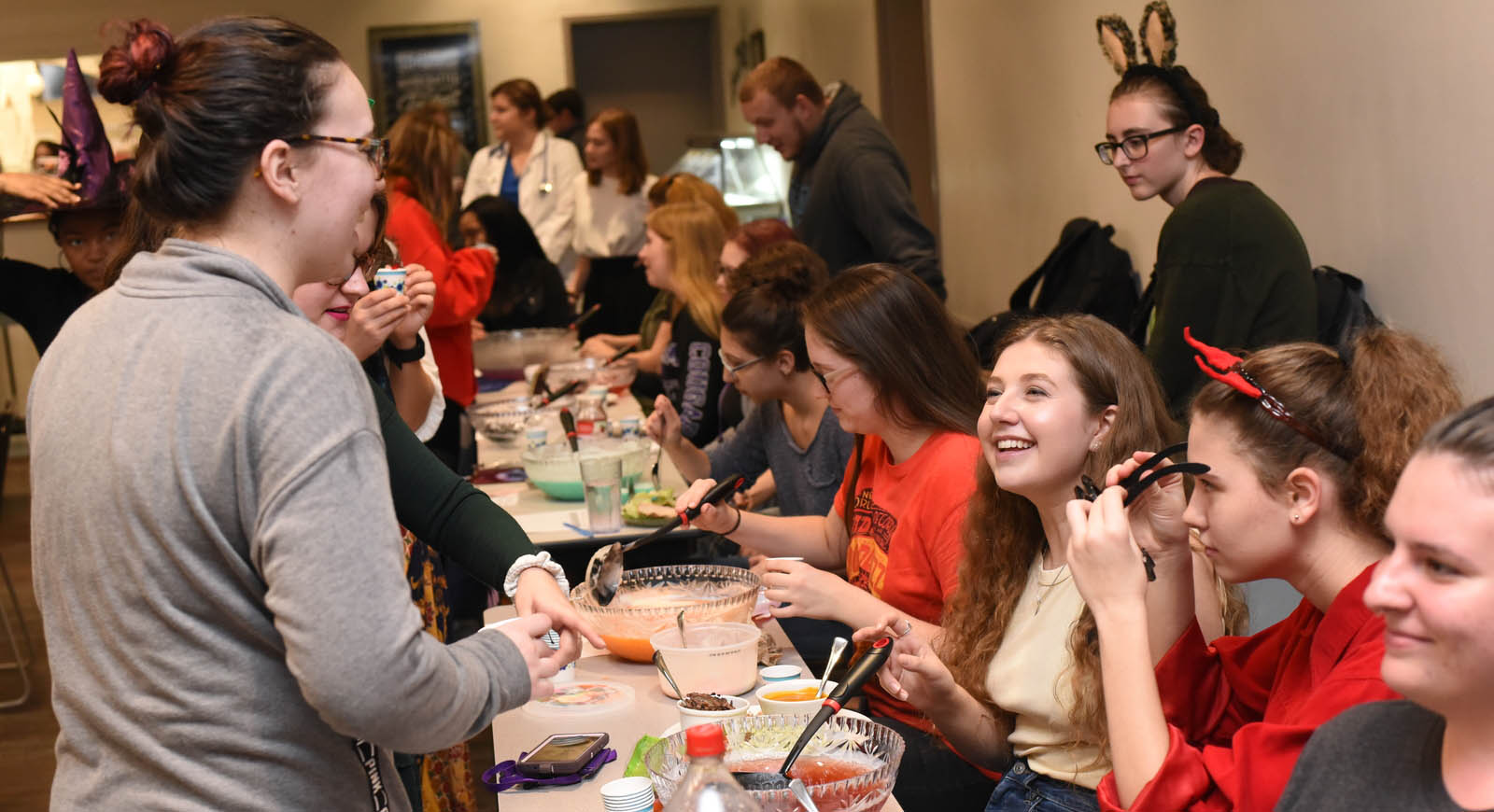 Photo of a group of students laughing and socializing at a mocktails event