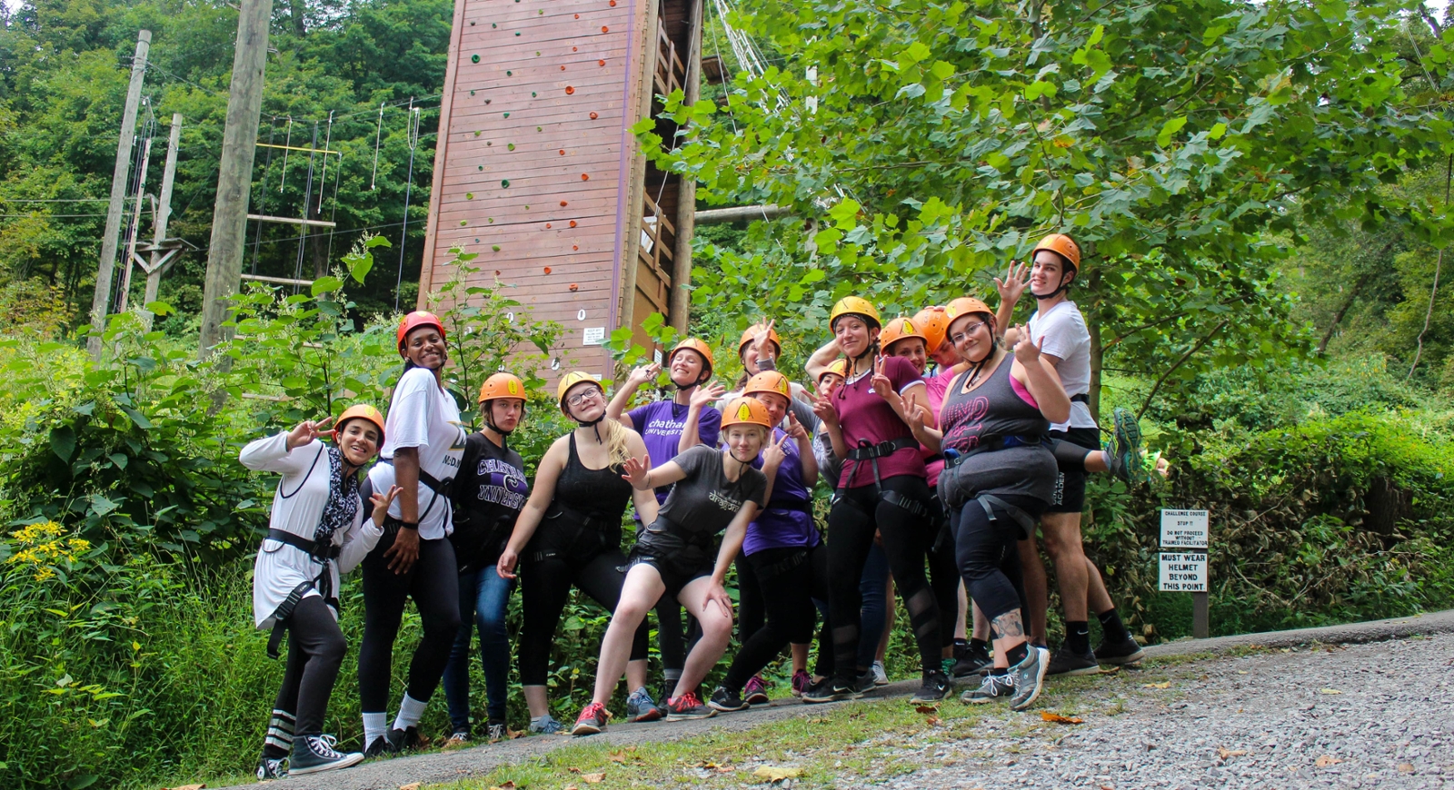 Photo of a group of Chatham University students at an obstacle course in the forest