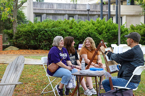 Photo of a group of Chatham University students pose together after doing yard work together during a volunteer day