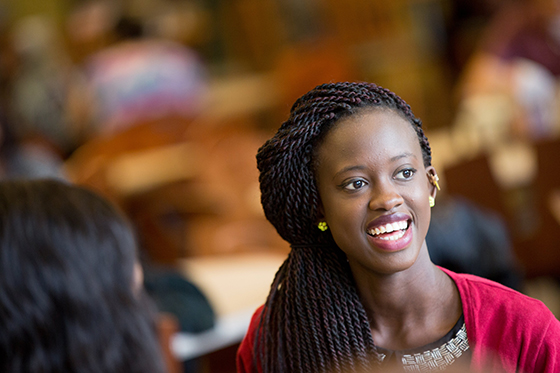 Photo of a young Black woman smiling in Chatham University's Anderson Dining Hall