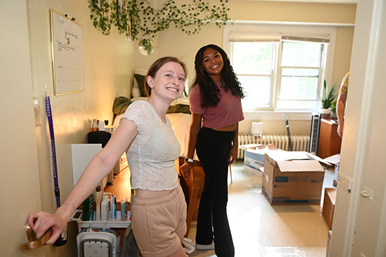 Two Chatham undergraduate students at the door of their dorm room
